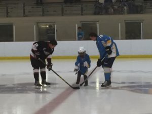 Children’s Wish child Same Dewey (middle) drops the puck for the captains of the Wear Well Bombers from Pictou County (left) and the host Bedford Barons before their game on Oct. 1 at the BMO Centre. (Healey photo)