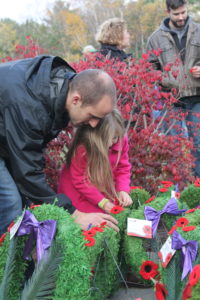 Four-year-old Miya Berringer, of Fall River, gets a helping hand from dad Brandon to place her poppy on a wreath following the Remembrance Day Service at the Waverley Legion on Nov. 11. (Healey photo)