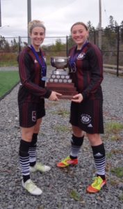 Fall River’s Nicole Fergusson and a teammate with the ACAA trophy after their Holland Hurricanes won the title. (Submitted photo)