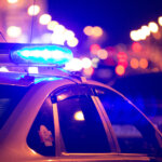 Blue,Light,Flasher,Atop,Of,A,Police,Car.,City,Lights